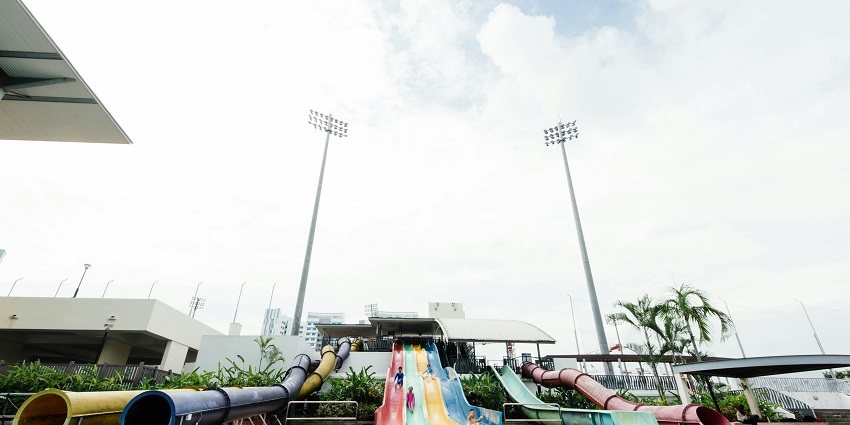 A picture of a tall water slide at a water park finishing up in a big swimming pool
