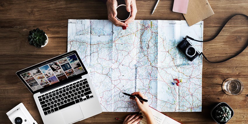 A table filled with a map, camera, notebook and other accessories.