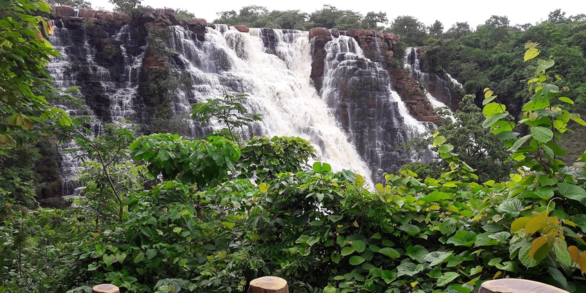Waterfall flowing down from block-shaped rocks and dividing into several small waterfalls.
