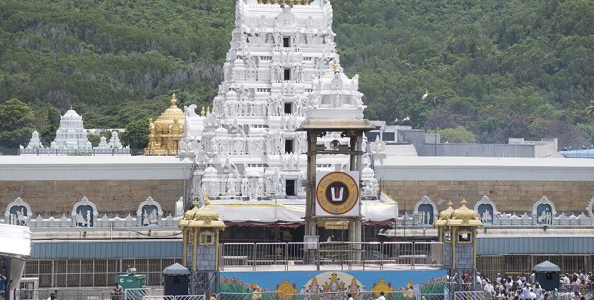 A picture of a temple taken from a distance with a tall white building in the middle of the compound