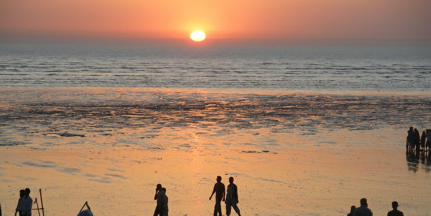 People enjoying a silent and relaxing evening at the Tithal beach.