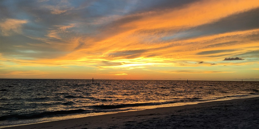 The tranquil views of the ocean and waves hitting the coastline during a sunset.