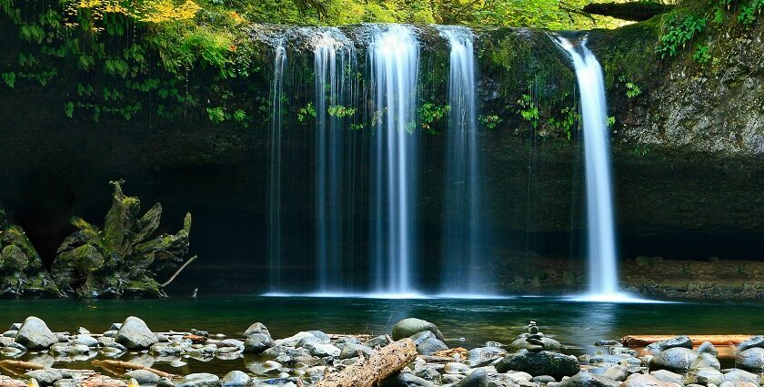 A breathtaking view of a waterfall in Arunachal Pradesh surrounded by lush greenery.