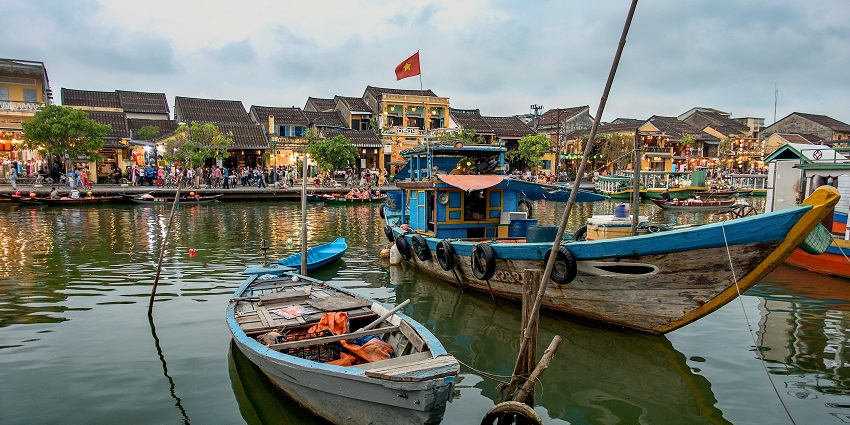 A glimpse of azure waters decked with boats and people on the coast in Tra Que Village.