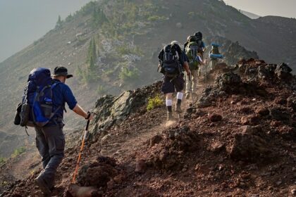 A fascinating view of a group of people hiking up rocky hills during the daytime.