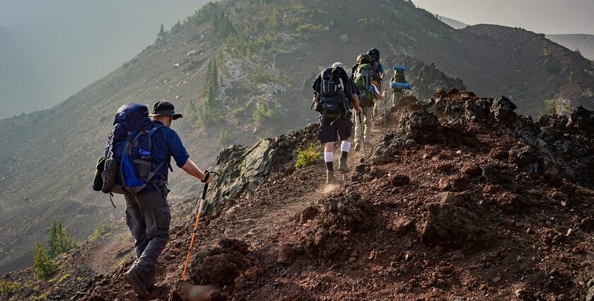 A fascinating view of a group of people hiking up rocky hills during the daytime.