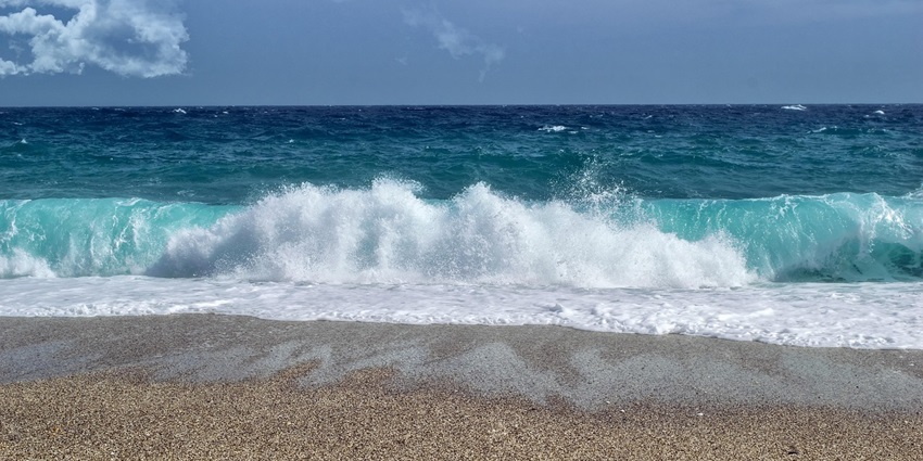 Waves gently lapping at the sandy shore, creating a tranquil scene during the daytime.