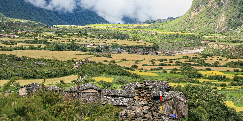 Scenic view of Tsum Valley with traditional Tibetan villages and rugged mountain landscape.