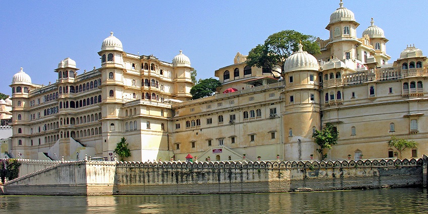 The City Palace of Udaipur has intricate balconies and majestic towers against a clear sky.