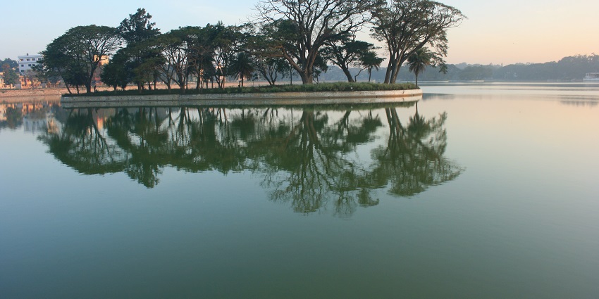 The placid waters of the Ulsoor lake and lush greenery near Fun World Water Park.