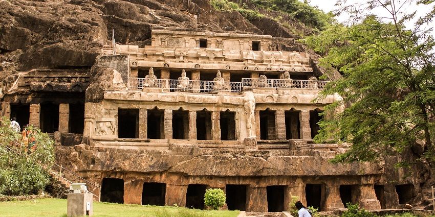 Image of ancient Undavalli Caves surrounded by lush greenery and mountains