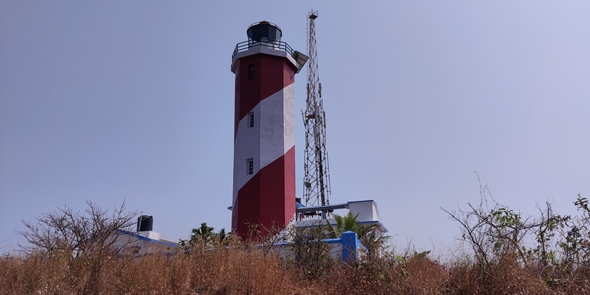 A scenic lighthouse perched on a hill, overlooking the Arabian Sea and fishing villages.