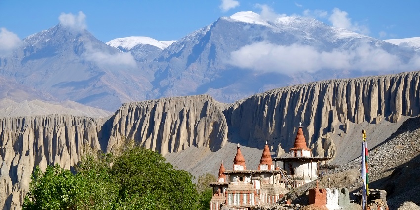 Arid landscape of Upper Mustang with ancient cliffside caves and desert-like terrain.