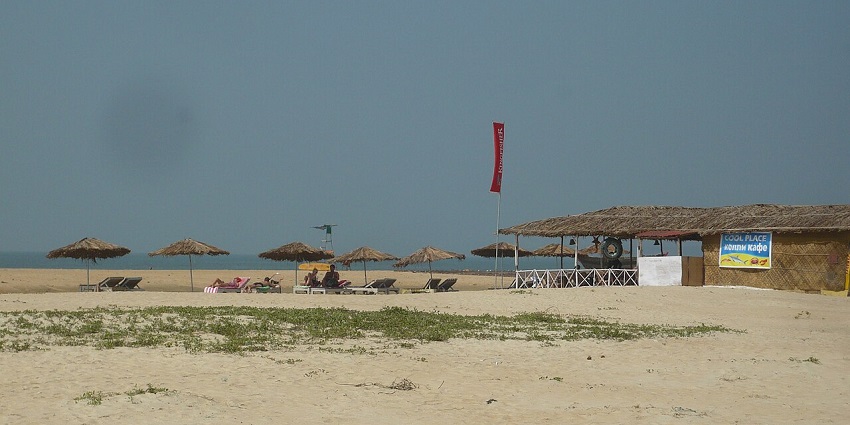 A picture of a beach with a shack at the shore, one of the best places to visit near Goa Airport