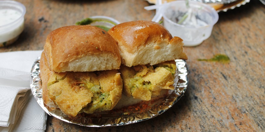 Try Vada Pav in Dilli Haat with a bottle of cold drink to satisfy your taste buds.