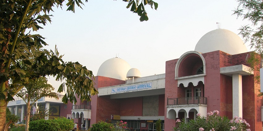 A view of the terminal building of Vadodara Airport with travellers and parked planes.