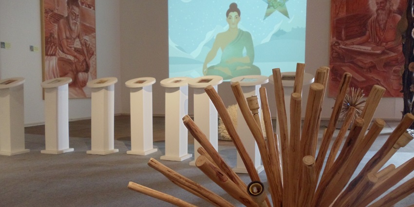 An indoor exhibit with artwork depicting what appears to be spiritual or religious figures