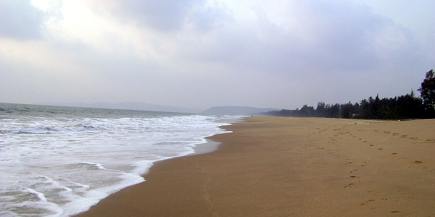 A breathtaking view of Vanalli features golden sands, soft waves, and a serene coastline.