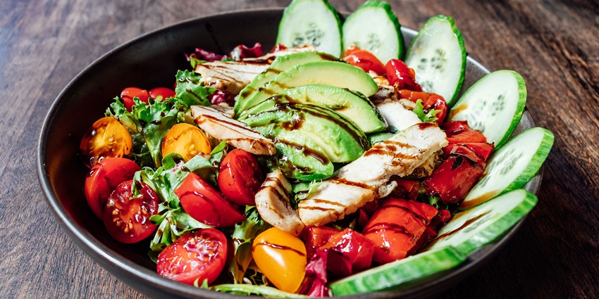 A bowl of fresh salads made of fresh veggies and served with different sauces