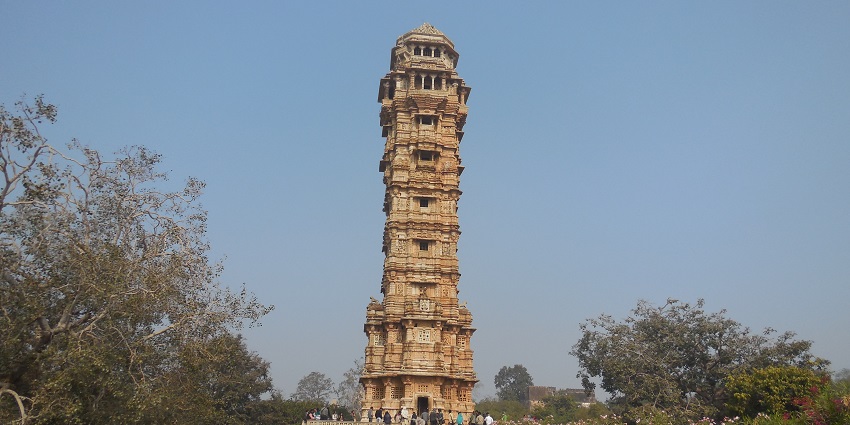 The Vijay Stambh stands tall on a sunny day in Rajasthan, amidst the scenic city of Chittor