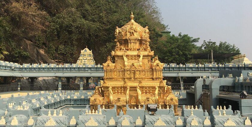 A picture of a temple with a golden building in the middle surrounded with the temple structure