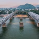 Aerial view of Vijayawada, India, showcasing urban landscape and river on a clear day.