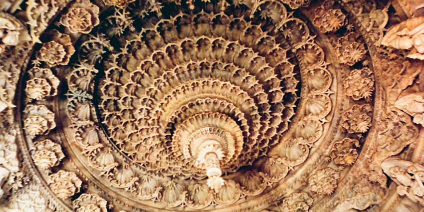 Interior view of the Dilwara Temple, featuring intricate marble carvings, detailed sculptures.