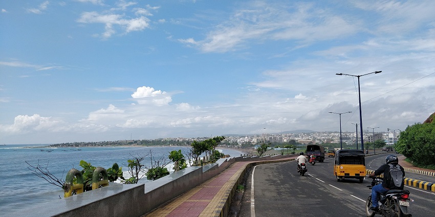 A picture of a road moving parallel to a beach and the seashore in Visakhapatnam