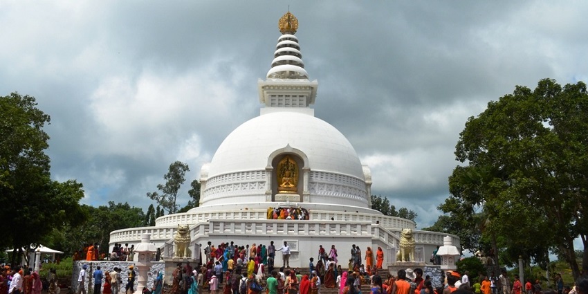 Vishwa Shanti stupa, a white peace pagoda in Rajgir, Bihar surrounded by greenery.