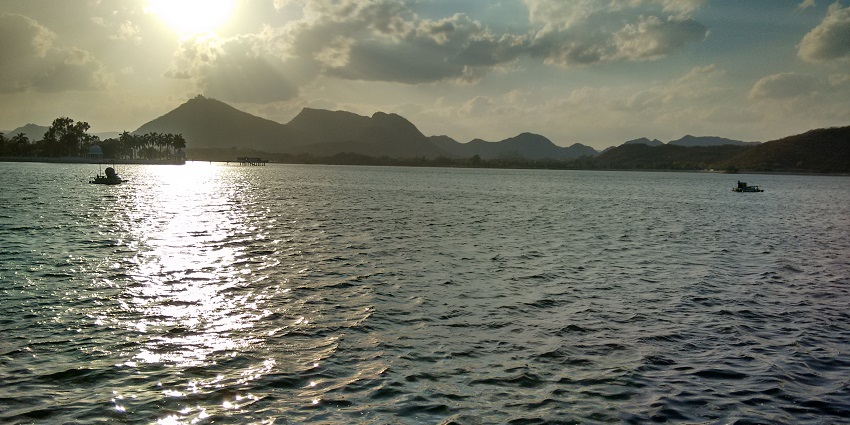 Fateh Sagar Lake in Udaipur, with calm waters and lush hills in the background