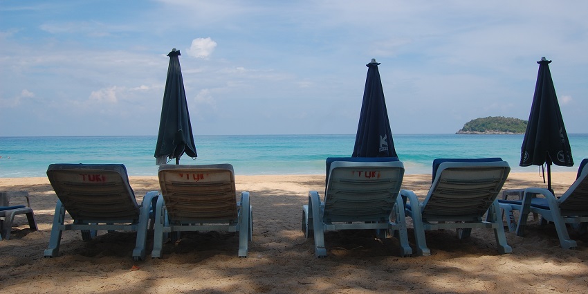 Pleasant day at Kata beach with pairs of lounge chairs and a sun umbrella for couples