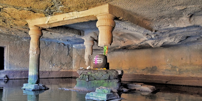 Cave temple of Kedareshwar with monsoon stream flowing over the rock cliff in Sailana, Ratlam.
