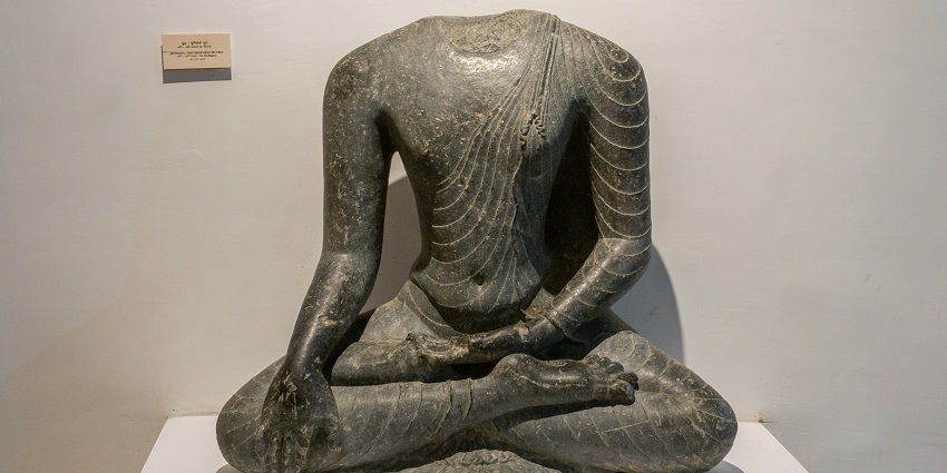 The stone Buddha sculpture, which is seated in Bhumisparsha Mudra, represents enlightenment in Gaya Museum.