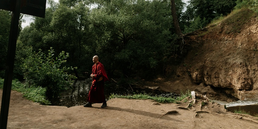 Image of a monk walking in the forest - lush greenery attraction near the monastery