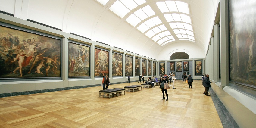 People walking through the gallery adoring the beautiful paintings in the Museums in Raipur.
