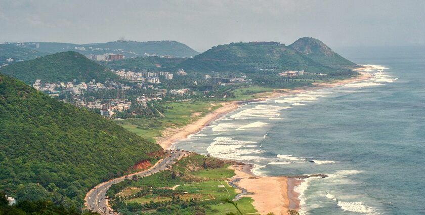 An aerial picture of a coastline with green hills and residential apartments all around