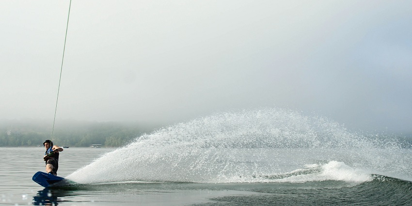 An image of a person wakeboarder performing the water sport in the middle of the ocean.