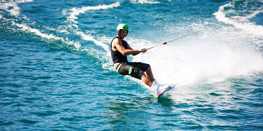 View of a women wakeboarding with a cable attached for safety