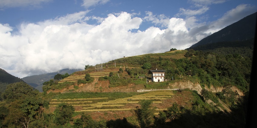 A picture of a scenic landscape in Bhutan showing its rolling hills and verdant valleys from a distance