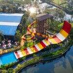 An aerial view of a leisure hub decked with colourful slides and sprawling pools.