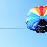 An amazing view of a colourful parachute in the clear blue sky during the daytime.