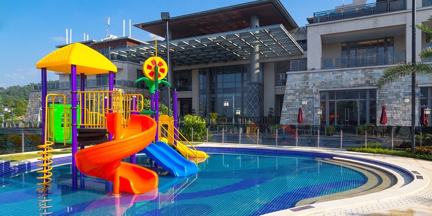 Aerial view of a vibrant water park surrounded by towering high-rises, like Water World