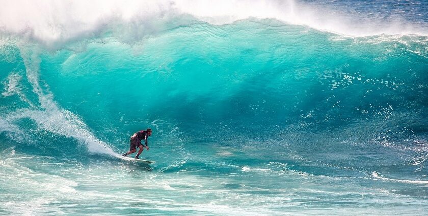 A person surfing amidst the shores, indulging in an adventure of a lifetime.