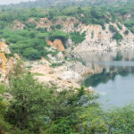 A picture of a lake surrounded by small hills and greenery