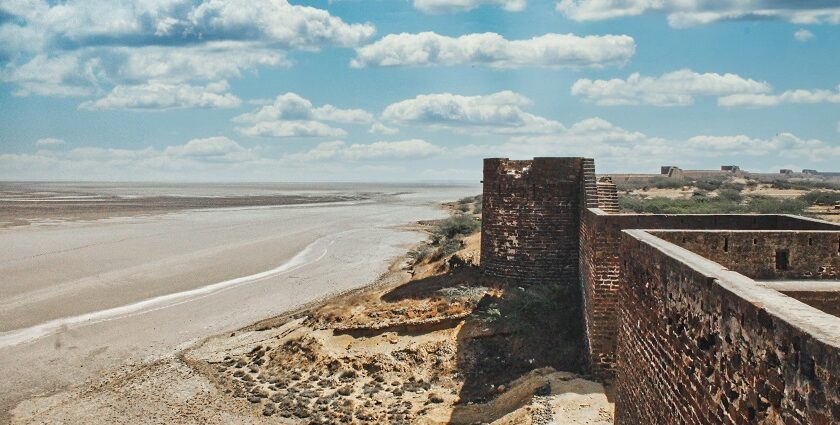 A breathtaking view of a historical fort with an azure water body on the side of it.