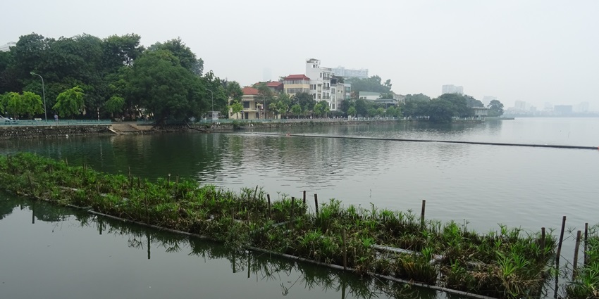 Scenic view of West Lake in Hanoi, surrounded by cityscape and lush greenery.