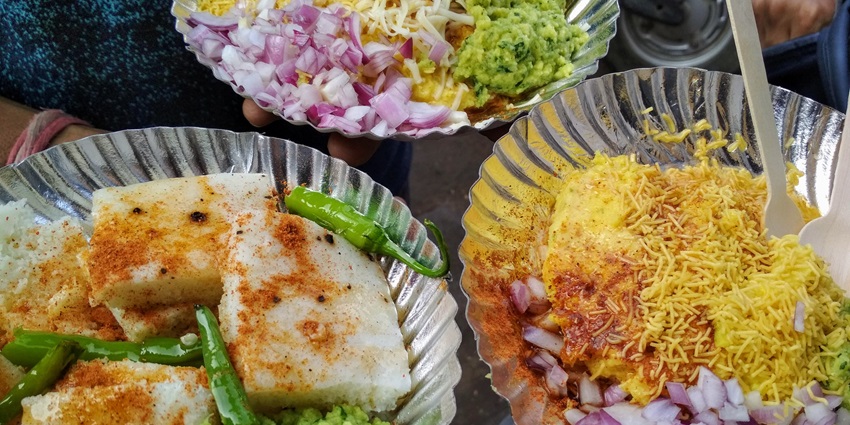 A plate of locho and idada, which are savory Gujarati snacks served together with vibrant colors and textures.