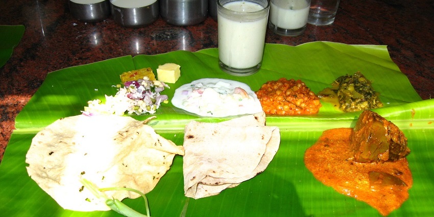 A selection of traditional Uttar Karnataka food, including various dishes served on a banana leaf.