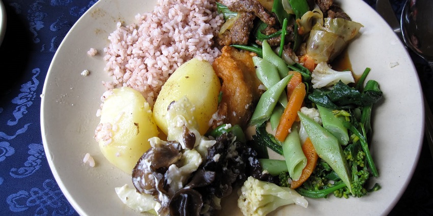 Relish a traditional Bhutanese meal featuring rice, vegetables, and local delicacies.