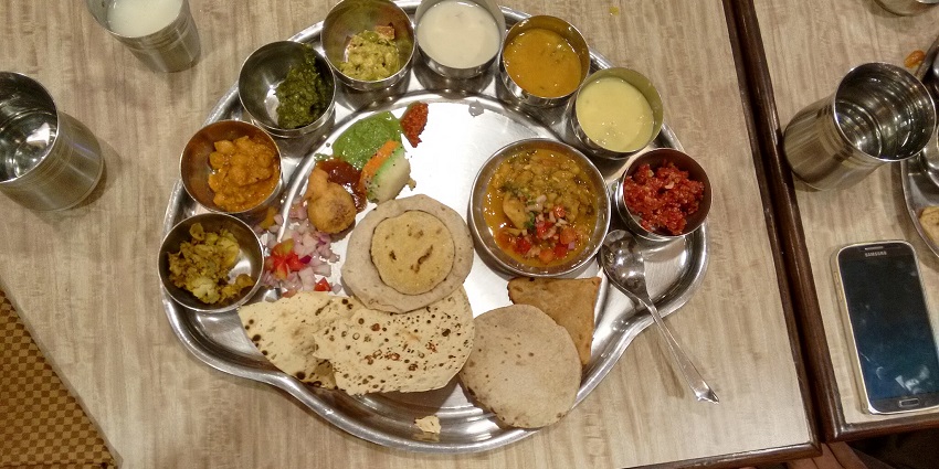 A vibrant Madhya Pradesh special thali showcasing an array of traditional Indian dishes.